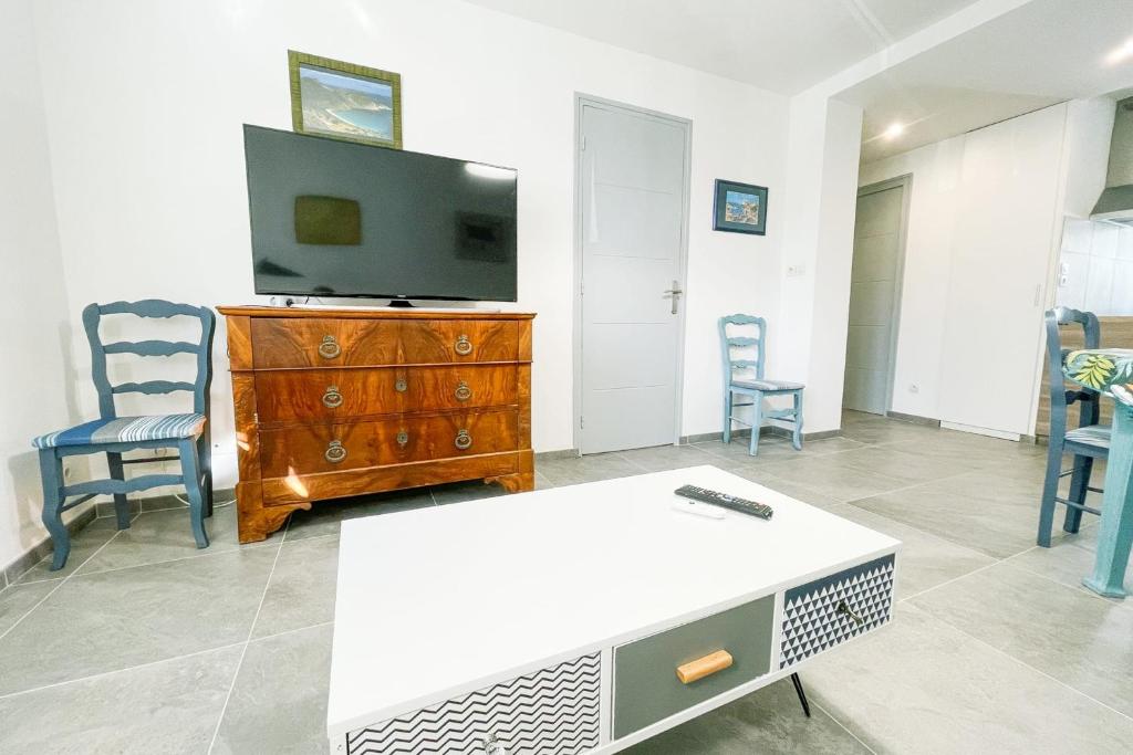 uma sala de estar com uma televisão e uma mesa e cadeiras em The pretty urban harmony - 2 rooms #GM em Grenoble