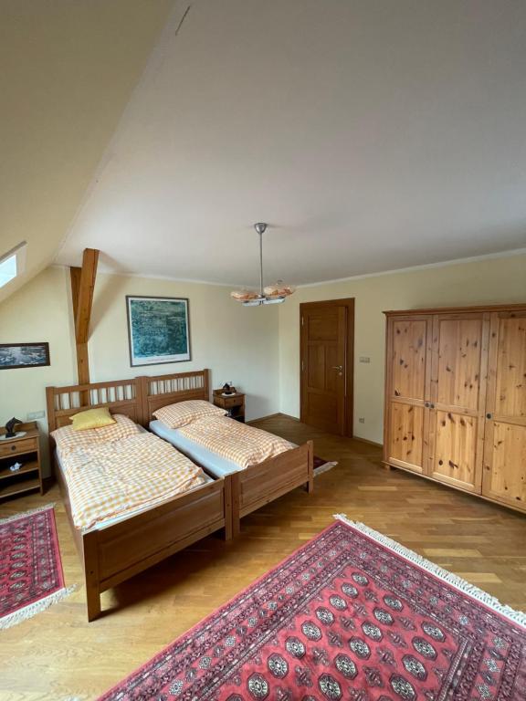 a bedroom with two beds and a red rug at Chalupa u Veseckých in Benešov