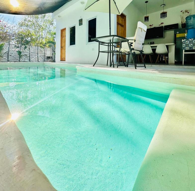 a large swimming pool with a table and chairs at Ola Azul Monterrico, apartamento de playa completamente equipado y con piscina privada. in Monterrico