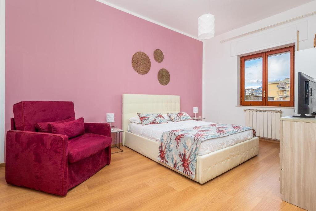 um quarto com uma cama e uma cadeira vermelha em Smart Home Sorrento - City center em Sorrento