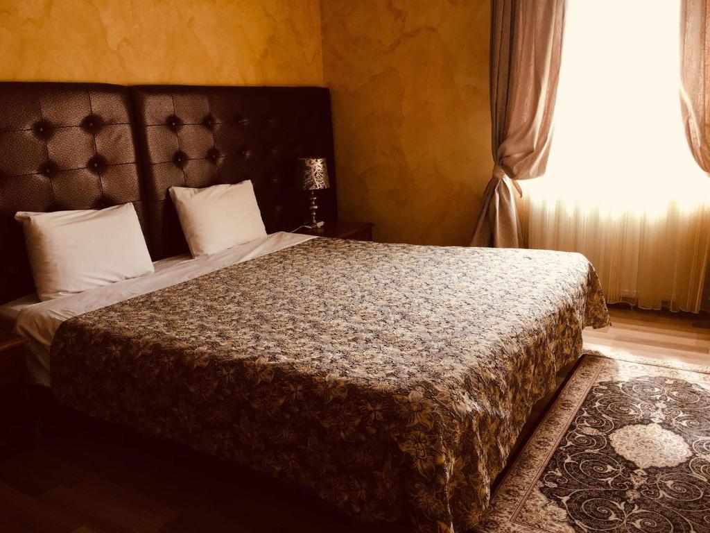a bedroom with a large bed with a large window at HOTEL ORA in Pristina