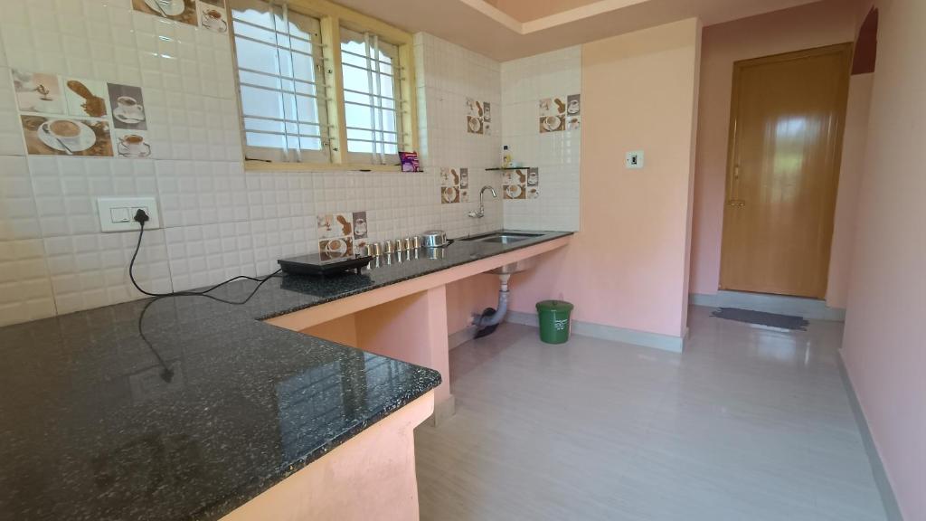 łazienka z czarnym blatem w pokoju w obiekcie S H coorg homestay w mieście Madikeri