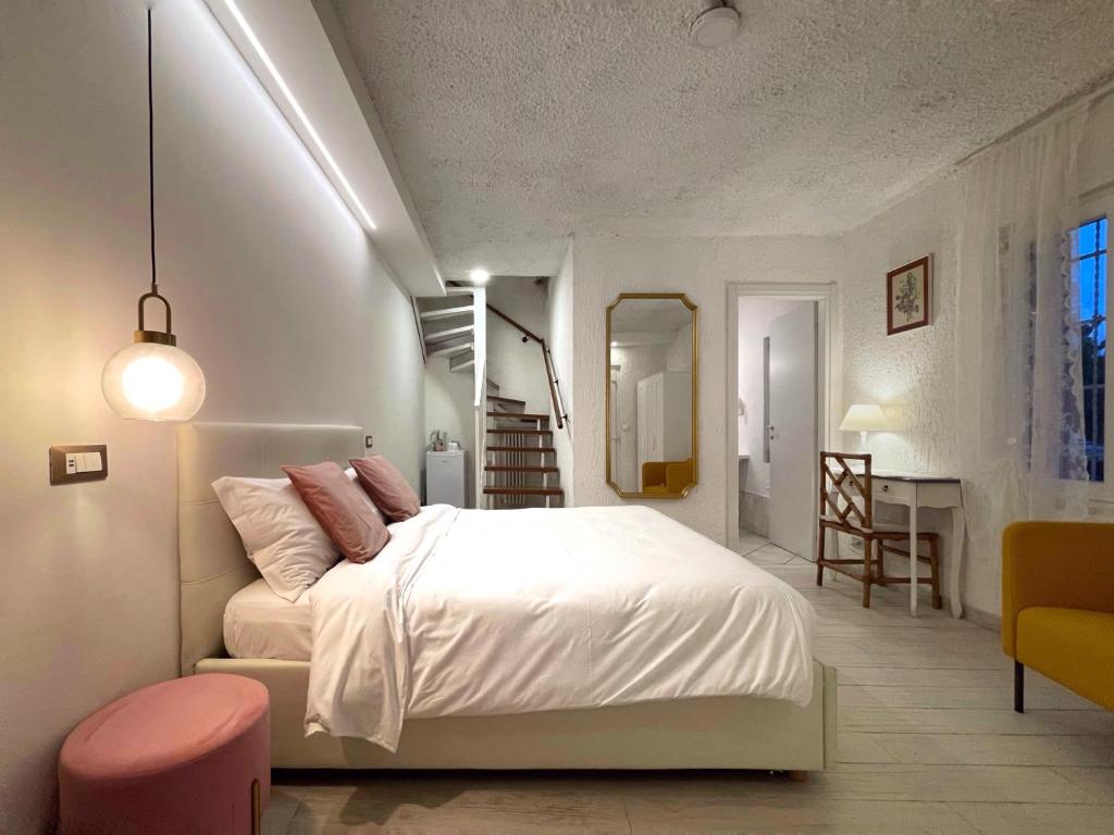 a bedroom with a white bed and a pink stool at Villa Pensione Mercedes in Sirmione