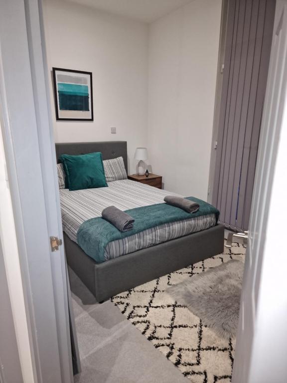 ein Schlafzimmer mit einem Bett mit grünen Kissen darauf in der Unterkunft Home away from home in Brierley Hill