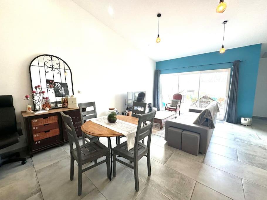 ein Wohnzimmer mit einem Tisch, Stühlen und einem Sofa in der Unterkunft Tout confort 4 chambres - Jacuzzi - Barbecue - Jardin in Libourne