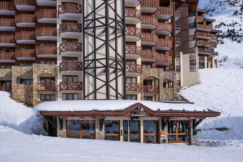 a building with snow on the ground in front of it at Résidence Pierre &amp; Vacances Les Néréides in Belle Plagne