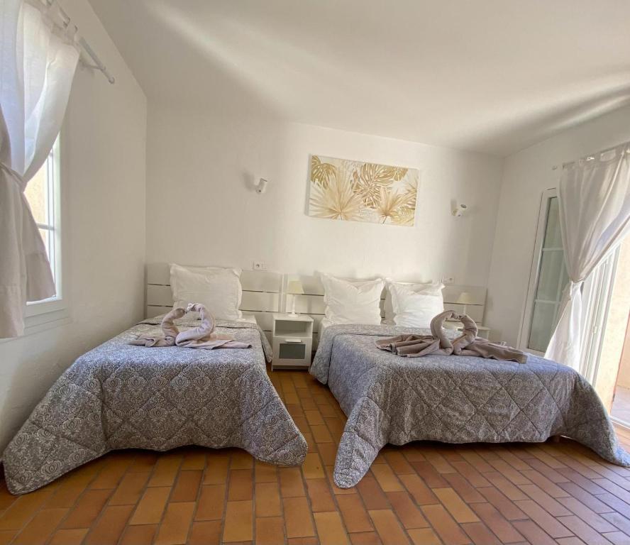 um quarto com 2 camas e toalhas em Le Refuge em La Croix-Valmer