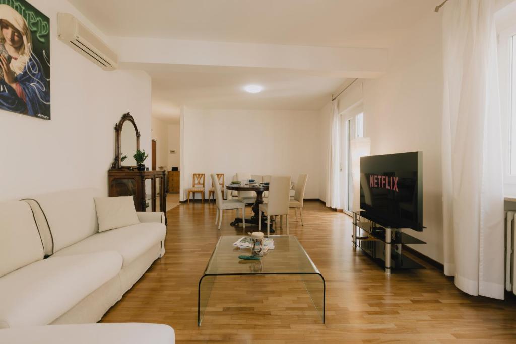 a living room with a white couch and a tv at Arena Luxury Apartment in Verona