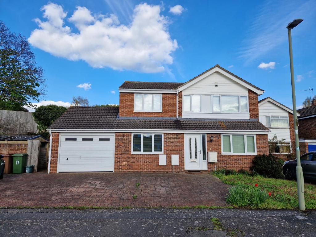 a brick house with a white garage at Isis Guest House in Sunningwell