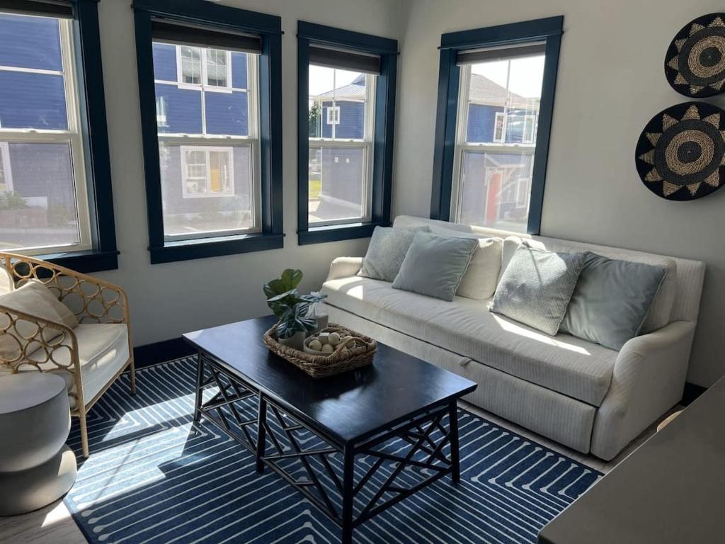 a living room with a couch and a table at Modern Cottage in the Heart of Charlevoix in Charlevoix