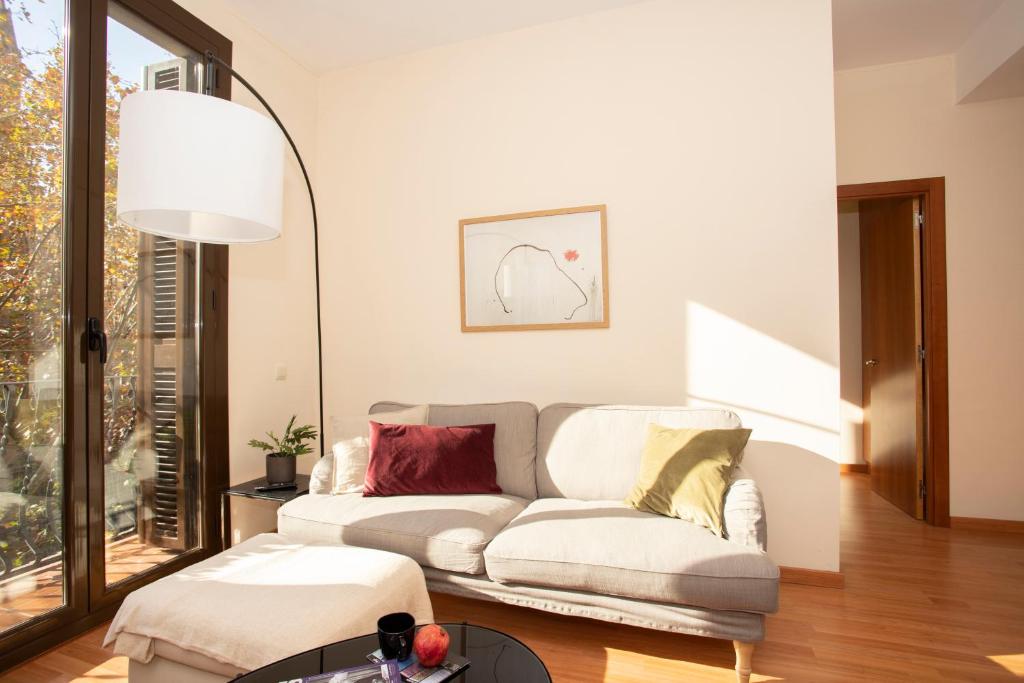 uma sala de estar com um sofá e um candeeiro em Bright Sunny Apartment in central Exiample em Barcelona