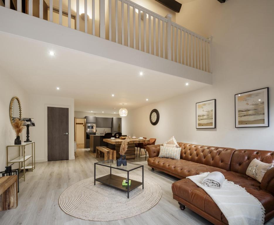 a living room with a couch and a table at Exclusive Penthouse- 85 Inch Huge TV in Bradford