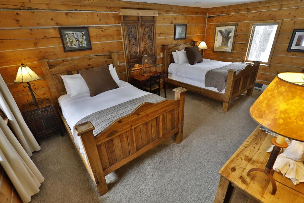 a bedroom with two beds in a log cabin at Bentwood Inn in Wilson