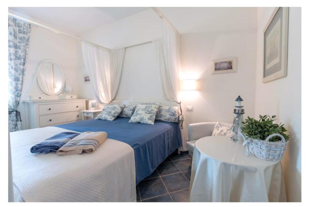 una camera con un letto blu e un tavolo di Residence Le Cenate a Santa Caterina di Nardò