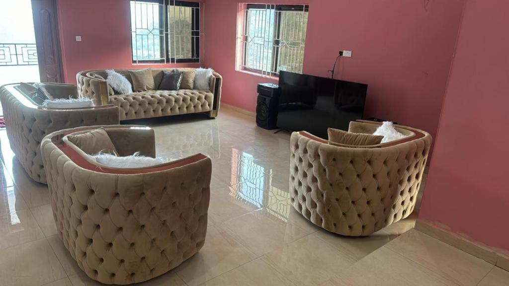 a living room with two couches and a piano at Prestigious Elegant Duplex - Abasscee in Freetown