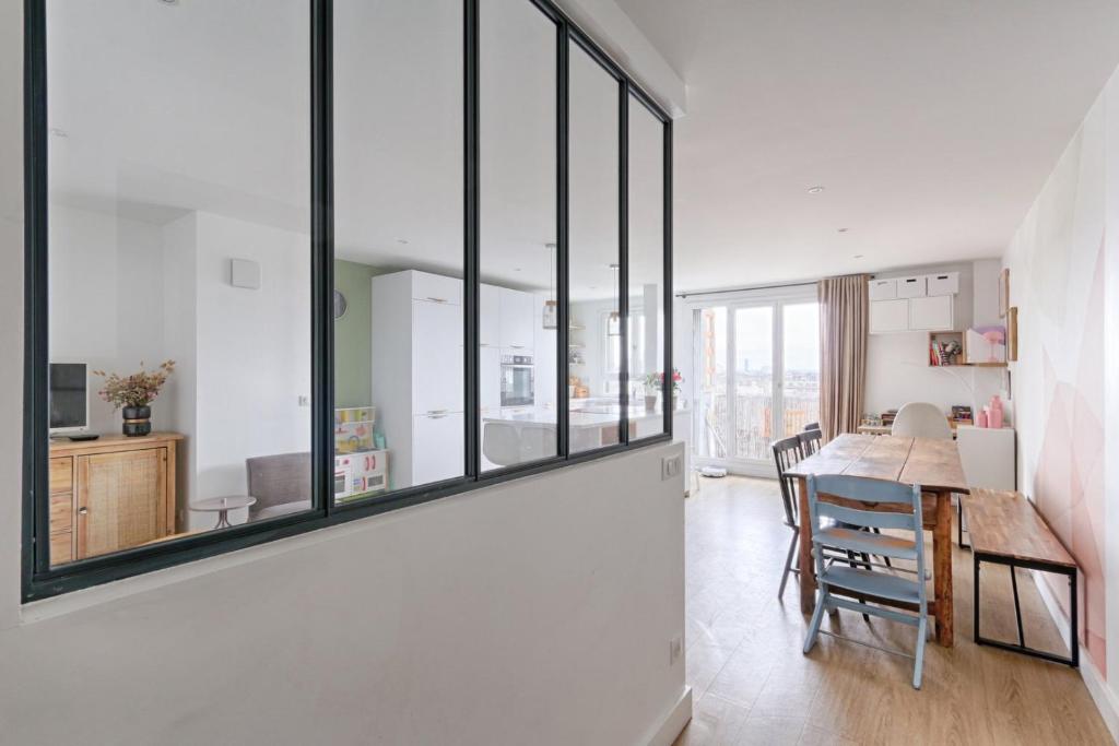 kuchnia i jadalnia ze stołem i oknami w obiekcie Résidor - Warm and bright 6P apartment! w Paryżu