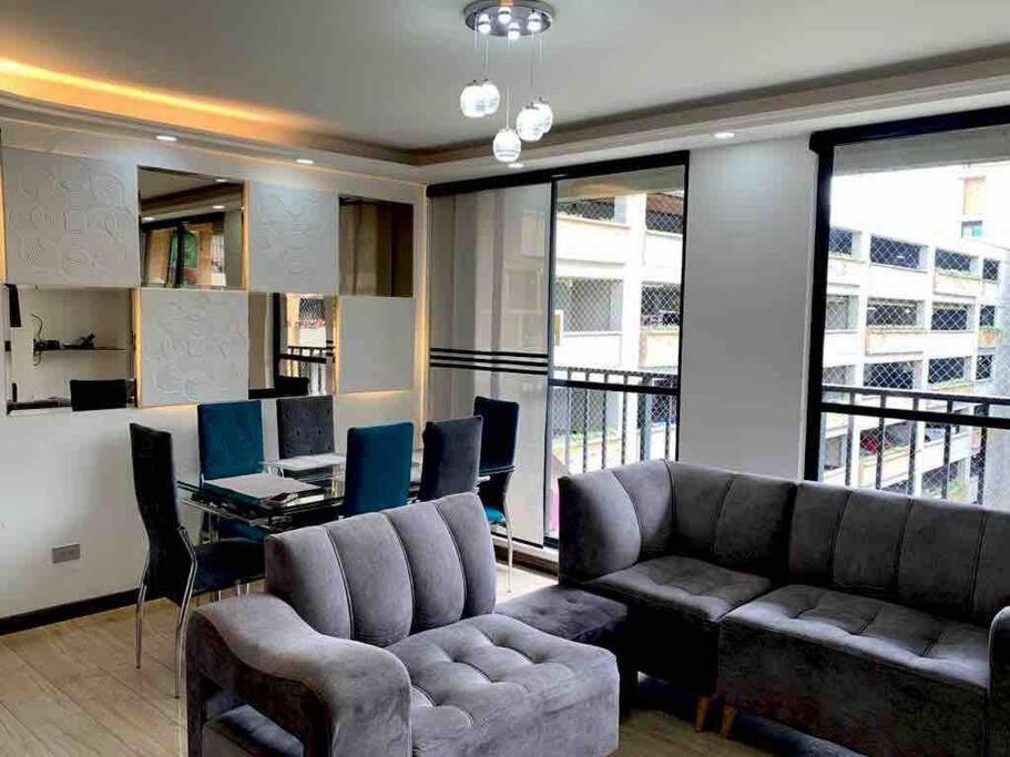 un soggiorno con divano e scrivania con computer di Lujoso, confortable y hermoso Apto en Funza, a Funza