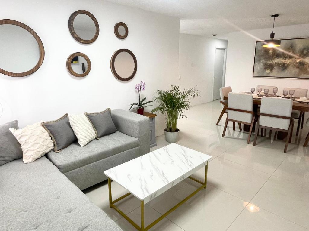 ein Wohnzimmer mit einem Sofa und einem Tisch in der Unterkunft Suite Jacarandas 103 in Guadalajara
