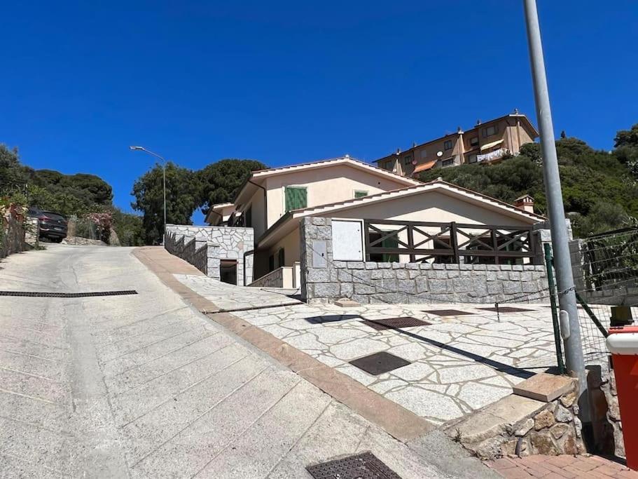 a house on the side of a street at Villetta con vista mare e parcheggio in Isola del Giglio