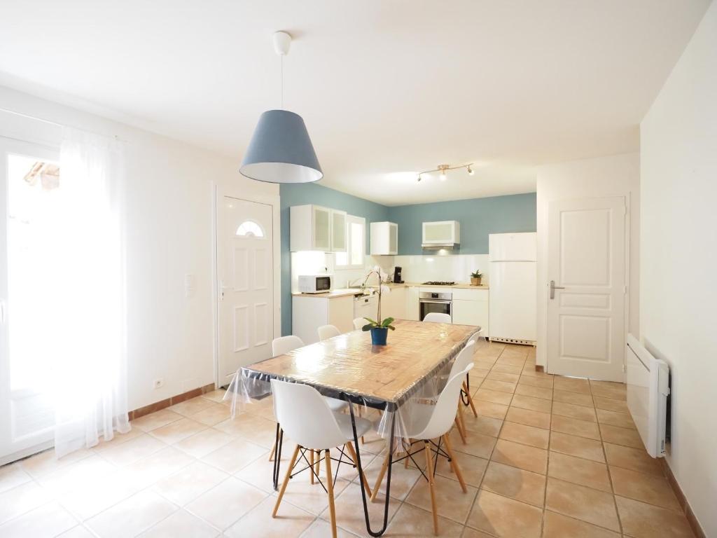 eine Küche und ein Esszimmer mit einem Tisch und Stühlen in der Unterkunft GITE DE LA TRUFFIERE "Les Truffes" in Montagnac