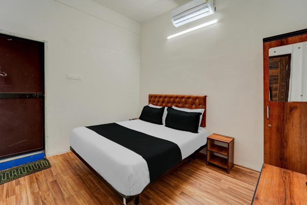 1 dormitorio con 1 cama con sábanas blancas y negras en OYO Flagship Hotel Blue Moon, en Patna