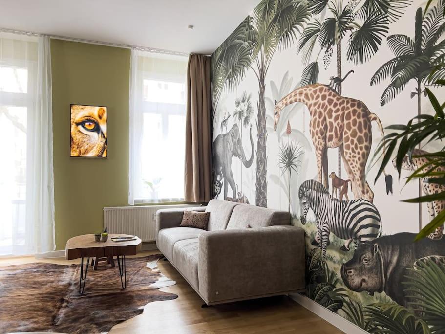 un salon orné d'une fresque murale représentant une girafe et un zèbre dans l'établissement Exklusives Apartment ZOO, à Leipzig