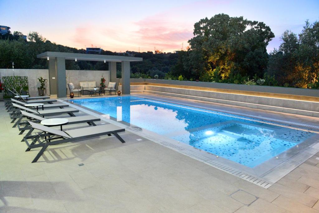 a swimming pool with chairs and a gazebo at Villa with private pool Zambakas in Kalithies