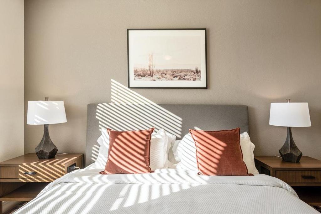 een slaapkamer met een bed met kussens en 2 lampen bij Landing - Modern Apartment with Amazing Amenities (ID1403X885) in Atlanta