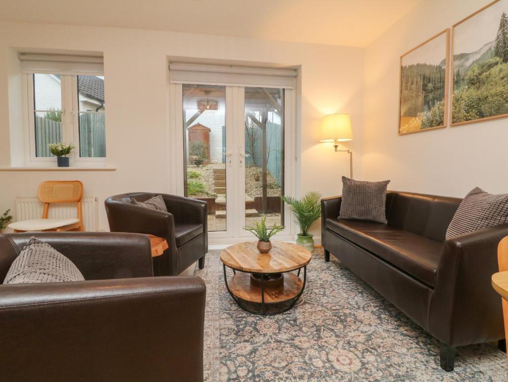 a living room with couches and a table at Reubens Cottage in Barnstaple