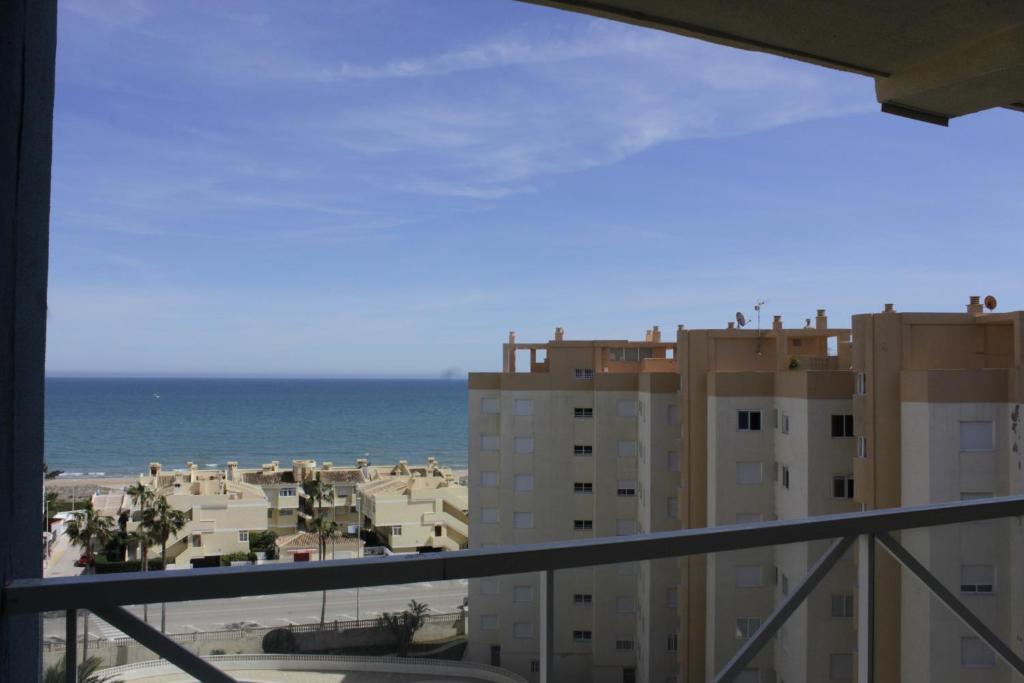 einen Balkon mit Blick auf das Meer und die Gebäude in der Unterkunft Mar Azul Solo Familias Serviplaya in Casas Las Basas