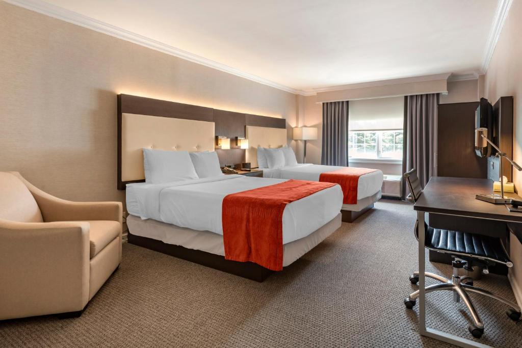 una camera d'albergo con 2 letti e una scrivania di Westminster Hotel a Livingston