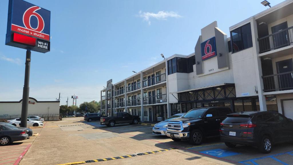 un estacionamiento con autos estacionados frente a un edificio en Motel 6 Houston, TX - Medical Center - NRG Stadium en Houston