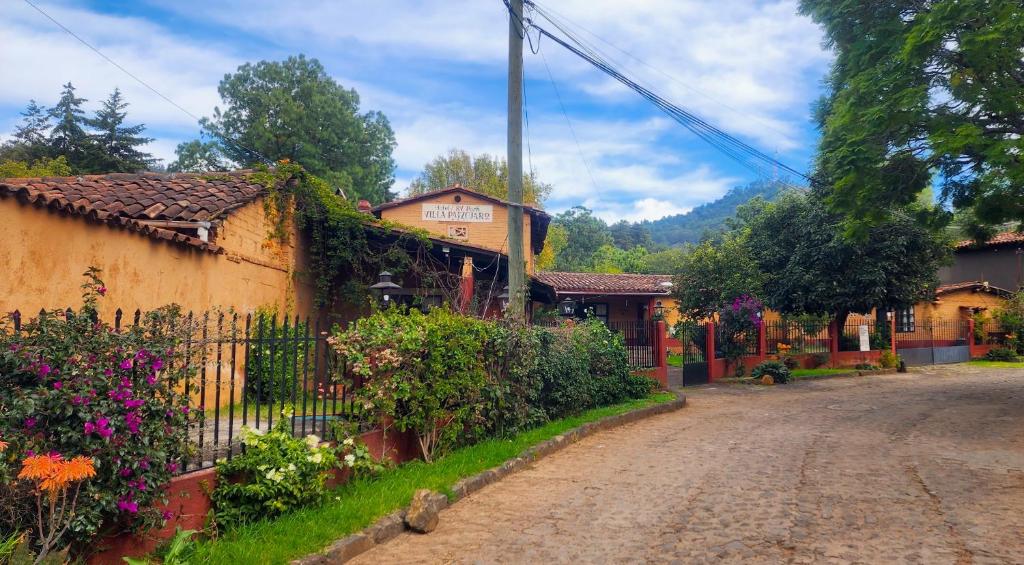 eine unbefestigte Straße in einem kleinen Dorf mit Blumen in der Unterkunft Villa Patzcuaro Garden Hotel in Pátzcuaro