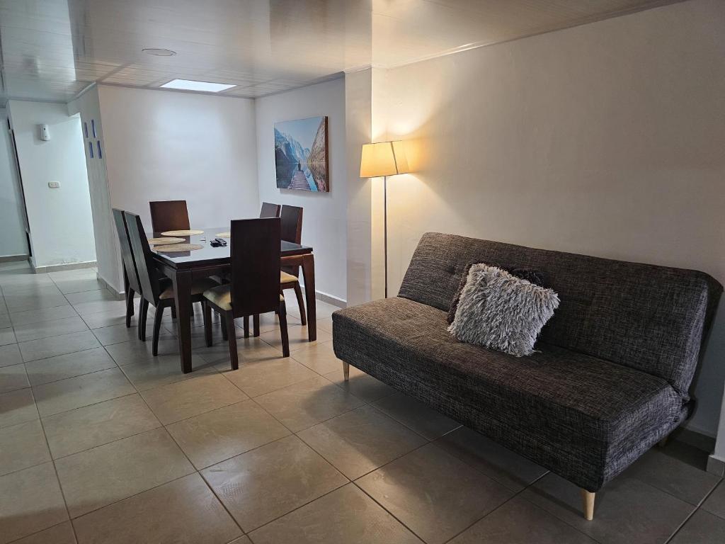 sala de estar con sofá y mesa con sillas en Espacioso Apartamento En Circunvalar Por Parceros Group, en Pereira