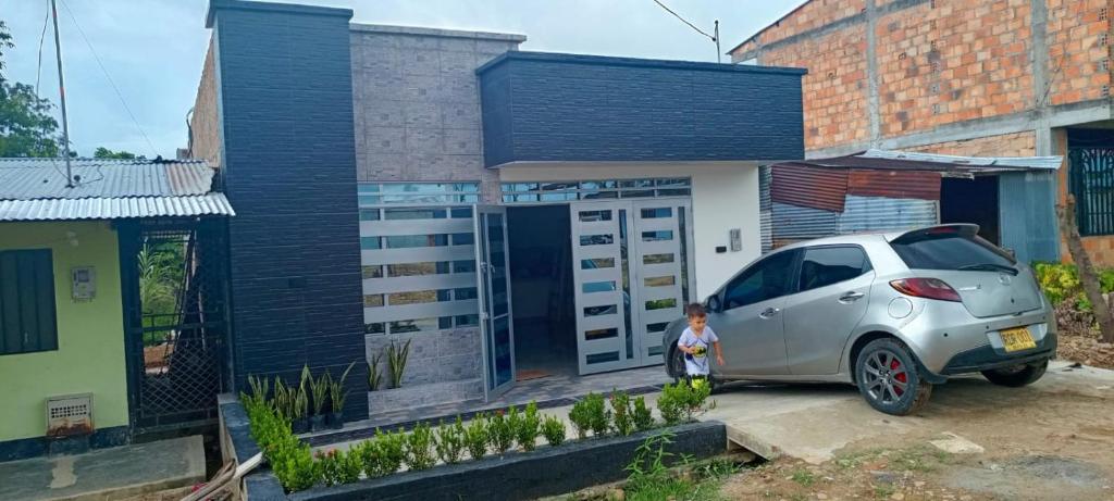 a little girl standing next to a car parked in front of a house at APARTAMENTO. ALQUILER POR DÍAS in San José del Fragua