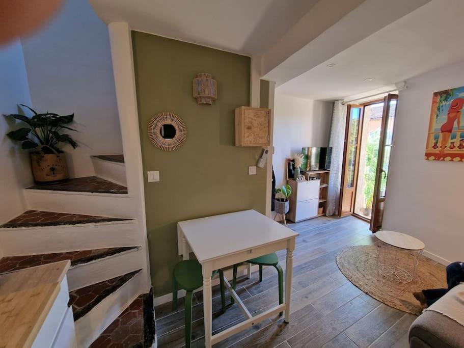 una sala de estar con una mesa en el centro de una habitación en Duplex dans maison de village, en Cagnes-sur-Mer