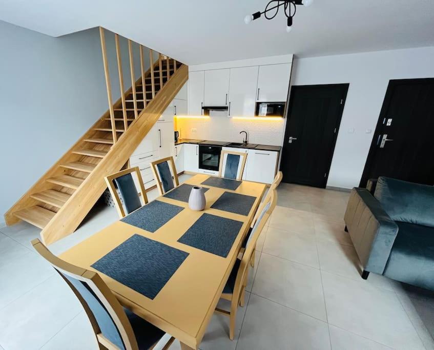 a dining table and chairs in a room with a staircase at Apartament Primula 2 in Jaworki