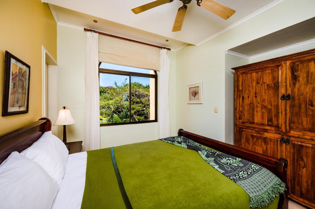 a bedroom with a bed and a window at Family Setting, Big Pool Beach Facing In Towns in Tamarindo