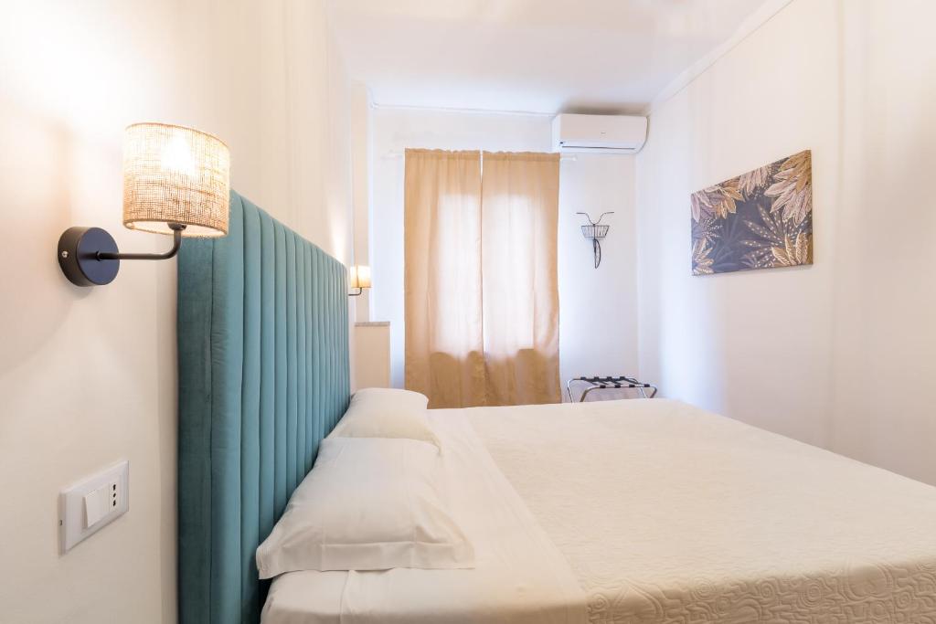 1 dormitorio con cama, lámpara y ventana en Hotel Castello, en Turín