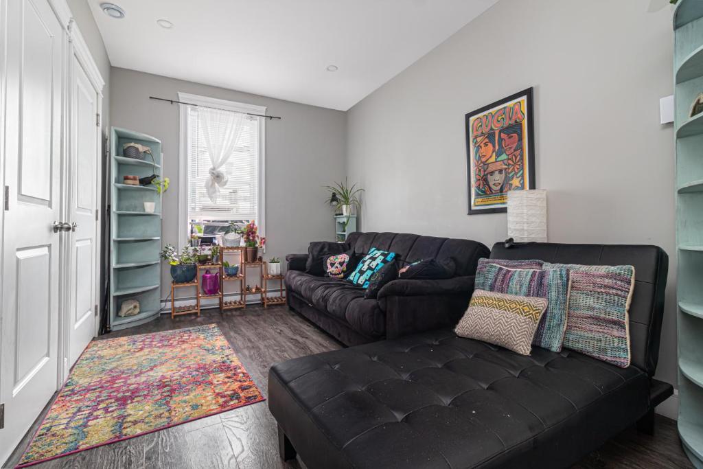 una sala de estar con un sofá de cuero negro en una habitación en Mi Casa Su Casa, Heart of Downtown St. John's, 1 BDRM Apt with Backyard en San Juan de Terranova