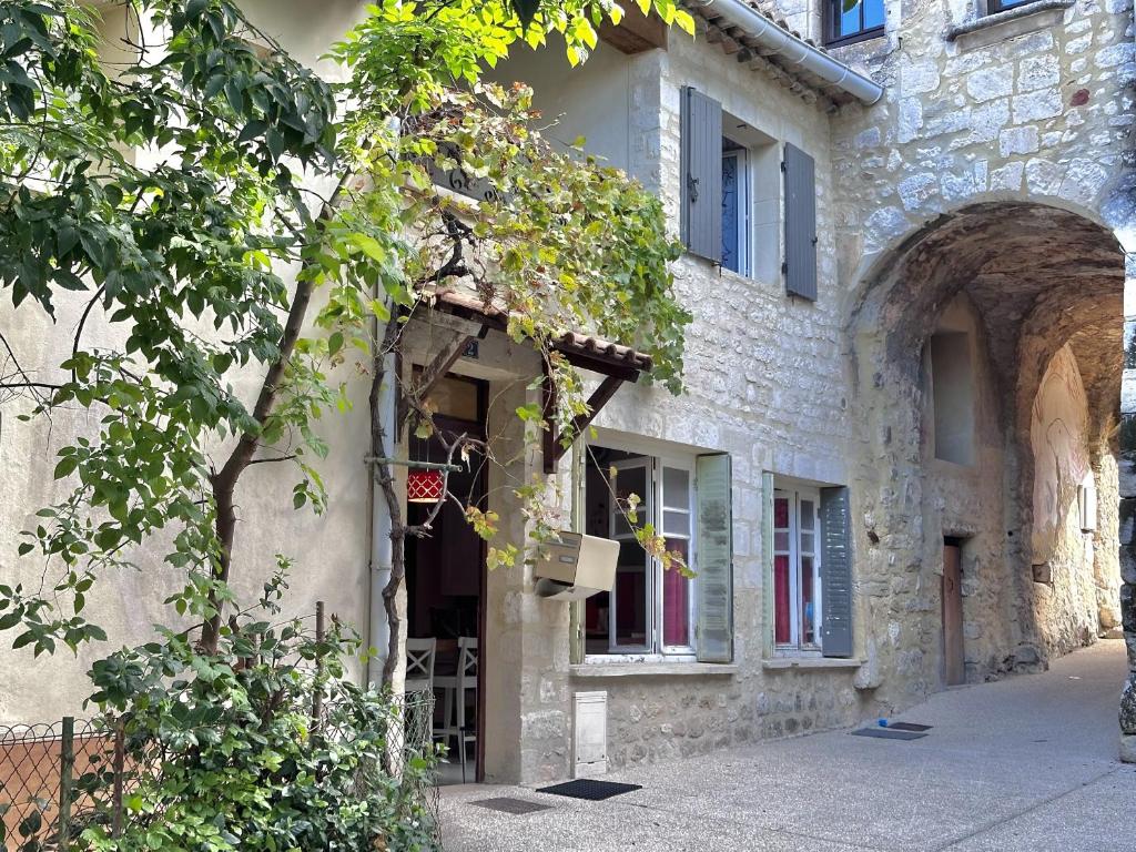 un ancien bâtiment en pierre avec un panier à l'entrée dans l'établissement La maison du Chateau, à Saint-Paul-Trois-Châteaux
