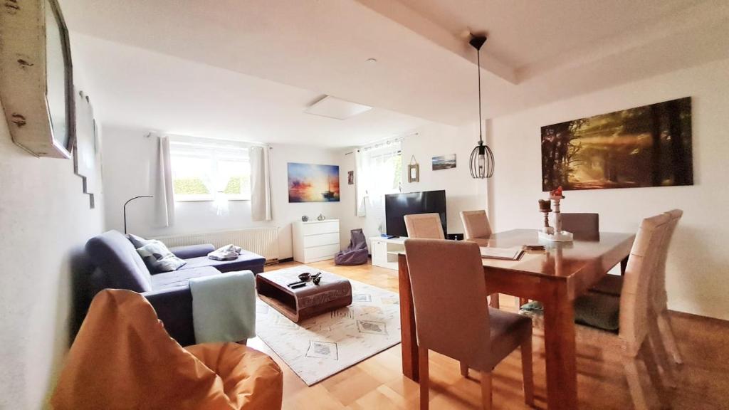 a living room with a table and a dining room at Apartment Neuweiher in Daisendorf