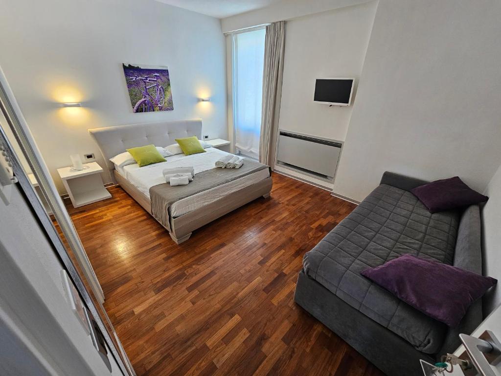 a small living room with a bed and a couch at B&B White con Parcheggio Privato in Porto Cesareo