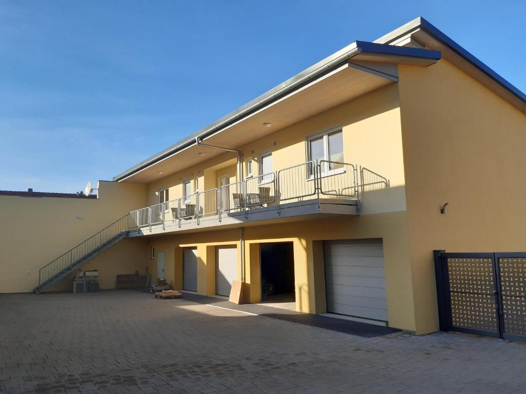 a large house with a balcony and a garage at Kleine Auszeit - Ferienwohnungen in Flonheim in Flonheim