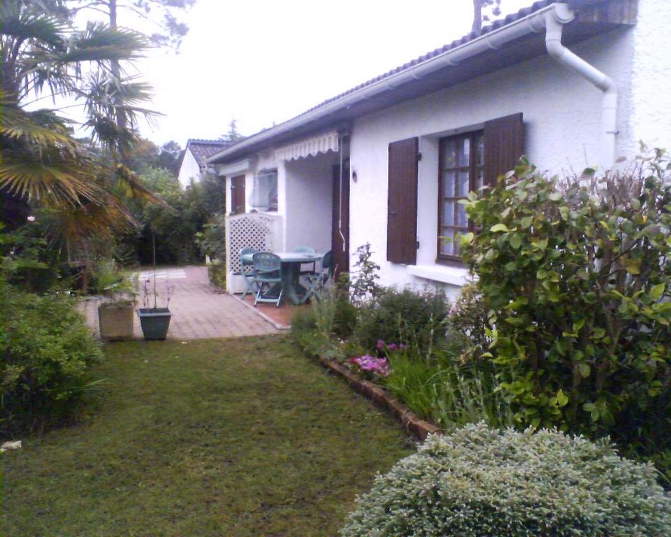 uma pequena casa branca com um jardim em frente em Vacances à Arès em Arès