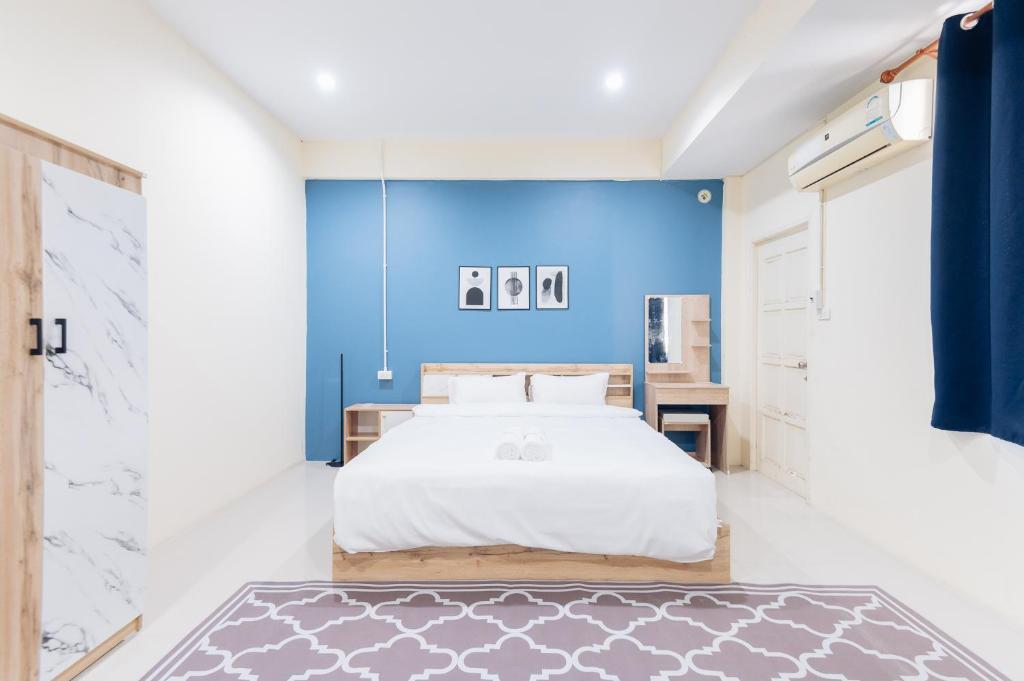 - une chambre avec un lit et un mur bleu dans l'établissement Hatyai Humble Home 03, à Hat Yai