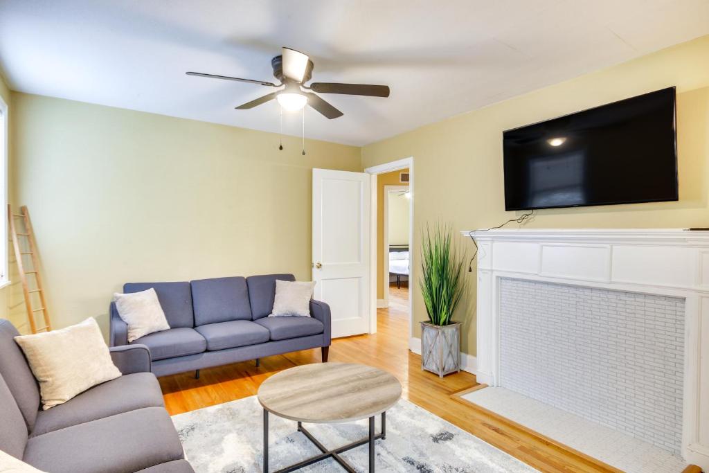 a living room with a blue couch and a tv at Augusta Home with Fenced Yard - 4 Mi to Downtown! in Augusta