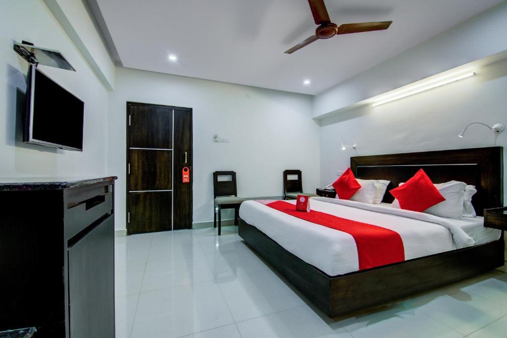 a bedroom with a large bed with red pillows at Super Collection O Ramachandra Residency in Kurmannapalem