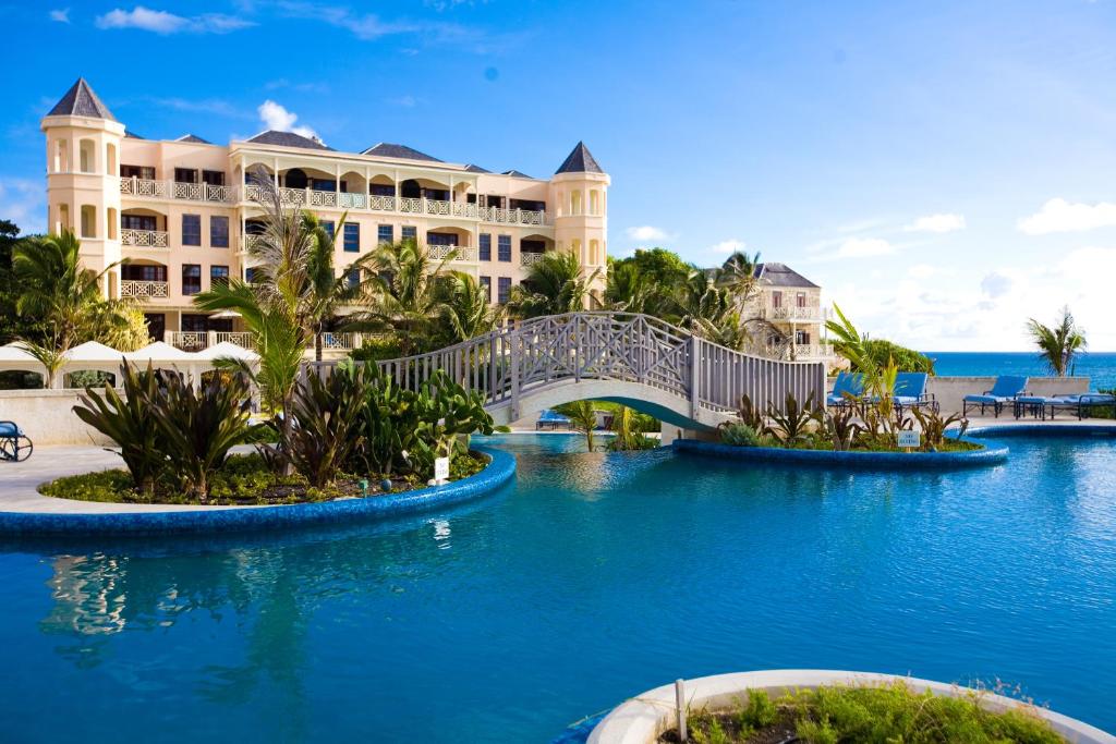 un puente sobre el agua frente a un complejo en The Crane Resort en Saint Philip