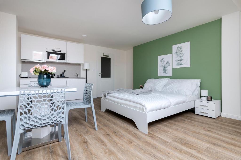 sypialnia z łóżkiem i stołem oraz kuchnia w obiekcie Central Haven Apartments w Pradze
